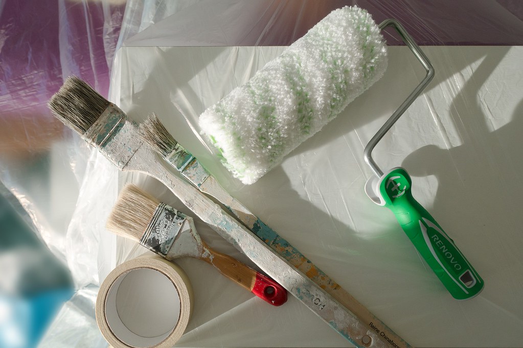 Paint brushes, roller and masking tape ready for home improvements