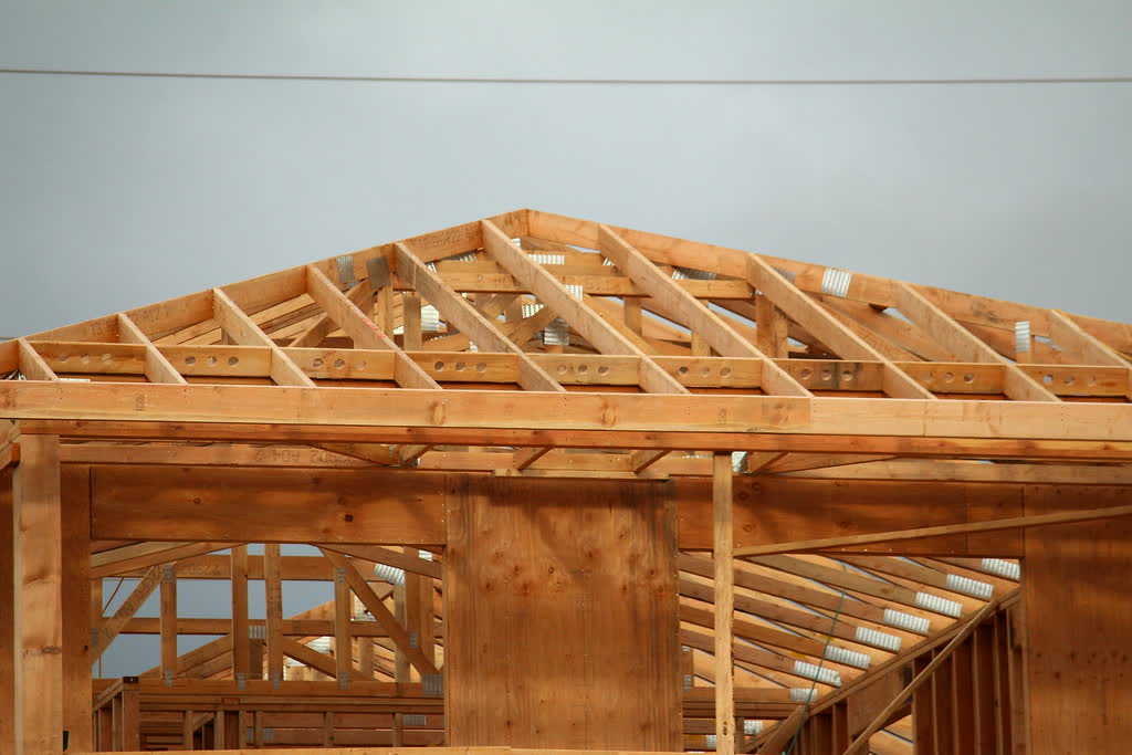New residential home under construction — timber roof trusses and wall framing